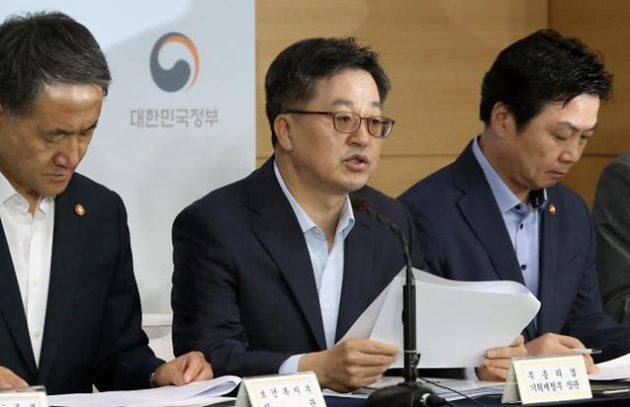 7月18日，韩国经济副总理兼企划财政部长金东兖（中）在首尔市政府大楼发布下半年经济政策方向和低收入阶层支援对策。（图片来源：韩联社）